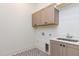 Practical laundry room featuring upper cabinets, granite sink, and patterned tile floor at 155 Gaines Trl, Pittsboro, NC 27312