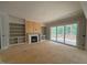 Spacious living room featuring a fireplace, shelving, and access to a deck through sliding glass doors at 155 Gaines Trl, Pittsboro, NC 27312