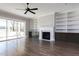 Bright living room with hardwood floors, fireplace, built-in shelving, and sliding doors to the backyard at 155 Gaines Trl, Pittsboro, NC 27312