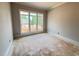 A bright, unfinished room featuring large windows offering natural light and a view of the neighborhood at 155 Gaines Trl, Pittsboro, NC 27312