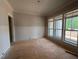 Bright, unfinished room featuring paneling and large windows, offering natural light and a view at 155 Gaines Trl, Pittsboro, NC 27312