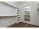 A well-lit walk-in closet with custom shelving and wooden racks for optimal storage and organization at 155 Gaines Trl, Pittsboro, NC 27312
