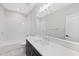 Modern bathroom with dark vanity, white tile, and a window at 2518 Silas Peak Ln, Apex, NC 27523