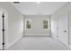 Spacious bedroom with carpet, two windows, and an adjacent door at 2518 Silas Peak Ln, Apex, NC 27523