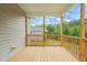 Relaxing covered back porch with wooden floor and railing offering an outdoor retreat at 148 Harmony Trl, Broadway, NC 27505