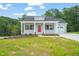 Charming single-story home featuring a red front door, gray siding, and well-manicured lawn at 148 Harmony Trl, Broadway, NC 27505