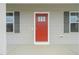 Close-up of a vibrant red front door with sidelight windows and contrasting gray shutters at 148 Harmony Trl, Broadway, NC 27505