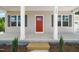 Inviting front porch featuring a bright red door, classic columns, and neat landscaping at 148 Harmony Trl, Broadway, NC 27505