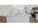 Kitchen island with white cabinets, stainless steel sink, granite countertops, and modern lighting at 148 Harmony Trl, Broadway, NC 27505