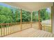 A porch with wooden railing and floors that overlooks an expansive yard surrounded by trees at 148 Harmony Trl, Broadway, NC 27505
