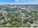 Stunning aerial view of lush neighborhood with city skyline, showcasing home's desirable location and mature trees at 918 N Blount St, Raleigh, NC 27604