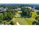 Aerial view of lush golf course and luxury home surrounded by mature trees and neighborhood at 1820 Oatlands Court Ct, Wake Forest, NC 27587