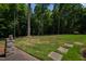Beautiful landscaped backyard featuring lush green grass, mature trees and stepping stones at 1820 Oatlands Court Ct, Wake Forest, NC 27587