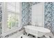 Charming bathroom with blue floral wallpaper and a clawfoot tub at 1820 Oatlands Court Ct, Wake Forest, NC 27587