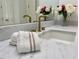 Close up of a bathroom vanity with white marble countertop and gold faucet set at 1820 Oatlands Court Ct, Wake Forest, NC 27587
