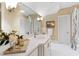 Well-lit bathroom with a large mirror, vanity with countertop, and decorative sconces at 1820 Oatlands Court Ct, Wake Forest, NC 27587