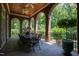 Inviting covered patio features brick arches, stone floor, and dining area overlooking lush greenery at 1820 Oatlands Court Ct, Wake Forest, NC 27587