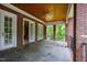 Charming covered patio with brick columns, slate tile flooring and a ceiling fan for outdoor relaxation at 1820 Oatlands Court Ct, Wake Forest, NC 27587
