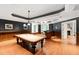 Entertain in this game room featuring a pool table, wood floors, dark gray walls, and custom wood trim accents at 1820 Oatlands Court Ct, Wake Forest, NC 27587