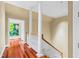 Upstairs hallway with hardwood floors, decorative columns, and abundant natural light from open doorway at 1820 Oatlands Court Ct, Wake Forest, NC 27587
