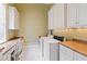 Functional laundry room with ample storage cabinets, workspace, and modern washer/dryer at 1820 Oatlands Court Ct, Wake Forest, NC 27587