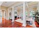 Bright and airy living room with hardwood floors, elegant columns, and a cozy fireplace at 1820 Oatlands Court Ct, Wake Forest, NC 27587