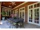 Covered brick porch with an outdoor dining table and white french doors at 1820 Oatlands Court Ct, Wake Forest, NC 27587
