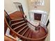 Elegant curved staircase featuring wood steps, iron railing, and chandelier, showcasing architectural detail at 1820 Oatlands Court Ct, Wake Forest, NC 27587