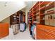 Organized walk-in closet with wooden shelves and hanging rods for ample storage, offering a custom and luxurious feel at 1820 Oatlands Court Ct, Wake Forest, NC 27587