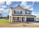 Two-story home featuring a covered front porch, dark shutters, and attached two-car garage at 300 Tuscany Cir, Princeton, NC 27569