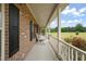 Long front porch with brick detail, and a view of the lawn beyond the railing at 2674 Stanton Hill Rd, Cameron, NC 28326