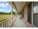 Long front porch of a brick home, featuring white railings and black shutters at 2674 Stanton Hill Rd, Cameron, NC 28326