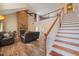 Inviting living room with stone fireplace, hardwood floors, and a staircase to a cozy loft at 2674 Stanton Hill Rd, Cameron, NC 28326
