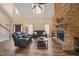 Bright living room features a stone fireplace, hardwood floors, and comfortable black leather furniture at 2674 Stanton Hill Rd, Cameron, NC 28326