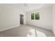 Bright bedroom featuring plush carpeting, a ceiling fan, and a bathroom, offering modern comfort and convenience at 7621 Falls Creek Ln, Raleigh, NC 27614