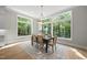 Elegant dining room with large windows offering scenic views, complemented by stylish decor and a chic area rug at 7621 Falls Creek Ln, Raleigh, NC 27614