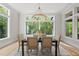 Bright dining room featuring a modern chandelier and expansive windows with views of the surrounding trees at 7621 Falls Creek Ln, Raleigh, NC 27614