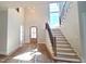 A grand entryway with a wooden door, high ceilings, staircase with black iron spindles, and abundant natural light at 7621 Falls Creek Ln, Raleigh, NC 27614