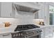 Chef's kitchen with a professional-grade range and custom hood, complete with modern finishes at 7621 Falls Creek Ln, Raleigh, NC 27614