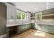 Well-lit kitchen with gray cabinets, floating shelves and a quartz counter at 7621 Falls Creek Ln, Raleigh, NC 27614