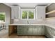 Stylish kitchen boasts sage-green cabinetry, quartz countertops, and modern fixtures at 7621 Falls Creek Ln, Raleigh, NC 27614