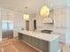 Modern kitchen with a large center island, stainless steel appliances, custom white cabinets, and pendant lighting at 7621 Falls Creek Ln, Raleigh, NC 27614