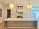 Bright, spacious kitchen with a large island, stainless steel appliances, white cabinets, and modern light fixtures at 7621 Falls Creek Ln, Raleigh, NC 27614