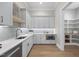 Well-lit kitchenette with white cabinetry, modern appliances, and quartz countertops, with a pantry in the background at 7621 Falls Creek Ln, Raleigh, NC 27614