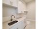 Modern laundry room with white cabinetry, quartz countertops and gold hardware, a blend of style and practicality at 7621 Falls Creek Ln, Raleigh, NC 27614