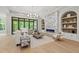 Bright living room with a marble fireplace, backyard views, and a neutral color palette at 7621 Falls Creek Ln, Raleigh, NC 27614
