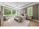 Serene main bedroom suite with tray ceiling, accent wall, a cozy sitting area, and large windows at 7621 Falls Creek Ln, Raleigh, NC 27614