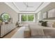 Bright main bedroom with hardwood flooring, tray ceiling, and a cozy sitting area next to a large window at 7621 Falls Creek Ln, Raleigh, NC 27614