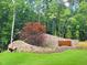 Stone entrance sign for Shinleaf Estates features colorful tree and lush green lawn at 7621 Falls Creek Ln, Raleigh, NC 27614