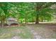 Spacious backyard featuring mature trees, outbuildings, and a stone pathway at 1844 Brier Ln, Graham, NC 27253